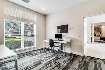 A room with a desk and a chair in front of a window.